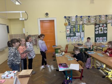 Den naruby: Paní učitelka v lavici, děti u tabule